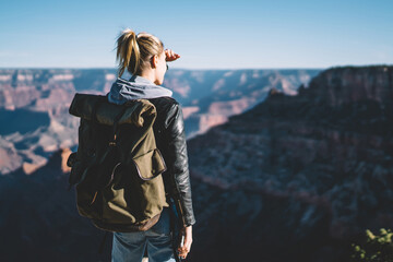 Wall Mural - back view of female traveler observing beautiful nature landscape on grand canyon, hipster woman wan