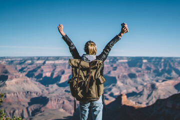 Wall Mural - back view of young wanderlust feeling victory conquering mountain in grand canyon, female traveler w