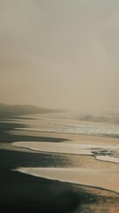 Wall Mural - A view of the ocean, waves merging with sandy dunes, as seen from a plane window