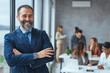 © Dragana Gordic - Successful business man smiling in a creative office. Portrait of happy mature man looking at camera indoor. Man with beard feeling confident. Close up face of hispanic business man smiling.