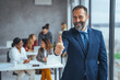 © Dragana Gordic - Cheerful businessman thumbs up posing and smiling at camera.  Portrait of happy business man looking at camera with copy space. Satisfied proud man feeling confident in a modern office.