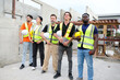 © krongthip - A team of male and female engineers stand smiling at a construction site for the housing industry.