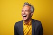 © Markus Schröder - Portrait of a content man in his 50s laughing while standing against solid color backdrop