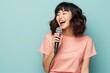 © Markus Schröder - Portrait of a satisfied asian woman in her 20s dancing and singing song in microphone over solid color backdrop