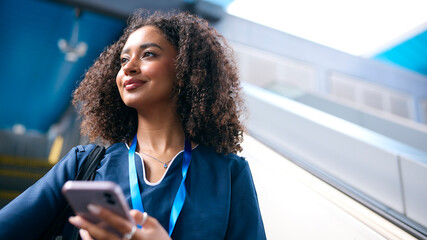 Female Doctor Or Nurse Commuting On Escalator At Railway Station To Train Platform