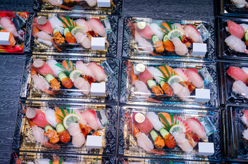 Various flesh sushi and sashimi ready to eat in plastic box package at Food shelves and freezers in seafood market