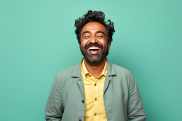 Canvas Print - Portrait of a joyful indian man in his 30s showing a thumb up isolated in solid pastel color wall