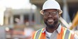 © gunzexx png and bg - Portrait of an African American construction worker smiling at a construction site