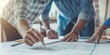 © gunzexx png and bg - A group of people are seen from above working together on architectural blueprints spread on a table