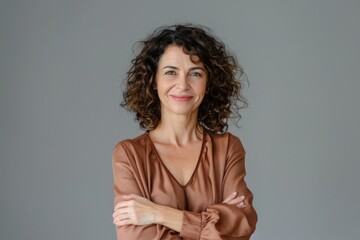 european woman. cheerful middle-aged female with curly hair smiling, isolated on grey background