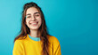 © Partha - joyful young woman standing against a blue background