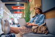 © Drazen - Smiling female traveler surfing  net on laptop at departure area