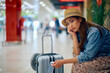 © Drazen - Young worried woman at departure area at  airport.