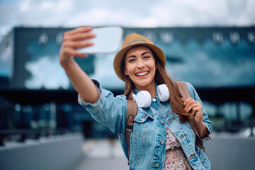 Wall Mural - Young carefree woman taking selfie at airport.