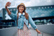 © Drazen - Happy woman having fun and taking selfie on her trip at airport.