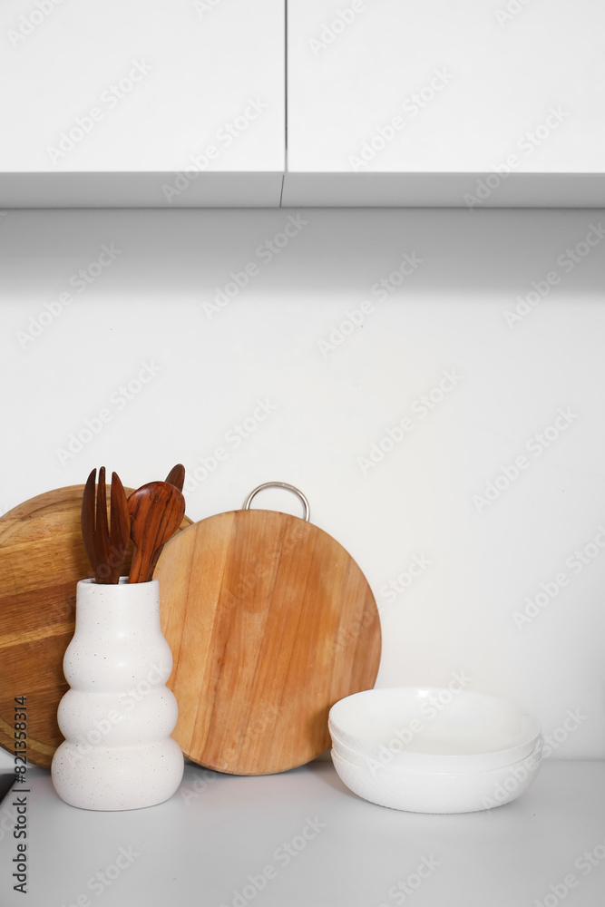 Bowls, cutting boards and kitchen utensils on white counter, closeup
