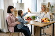 © sofiko14 - Little girl sits on mothers lap and gives high five to mature positive female nutritionist after successful treatment for indigestion. Concept of completing gastrointestinal treatment plan.