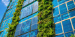 © dinastya - Modern sustainable building with solar panels, vertical garden with green plants.