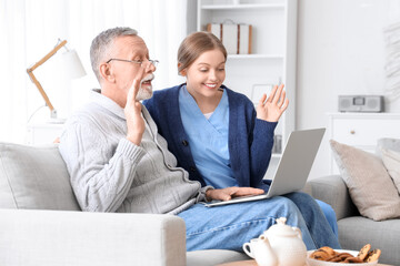 Poster - Female caregiver with senior man video chatting in nursing home