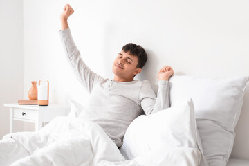 Wall Mural - Young man stretching in bedroom