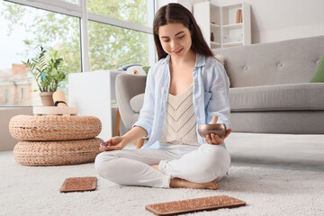 Poster - Young woman with Tibetan singing bowl and Sadhu board sitting at home