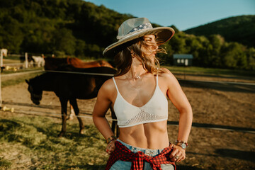 Wall Mural - Portrait of attractive cowgirl at horse ranch with wind in her hair.