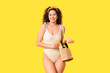 © Pixel-Shot - Beautiful young African-American woman in swimsuit with bottle of sunscreen cream in wicker bag on yellow background
