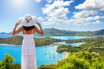 Wall Mural - a woman in a white summer dress enjoys the panoramic view over the landscape of antigua island with 