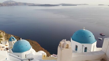 Canvas Print - white church belfry, blue domes and volcano caldera with sea landscape, establishing shot of Santorini island, Greece