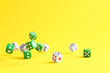 © New Africa - Many color game dices falling on yellow background