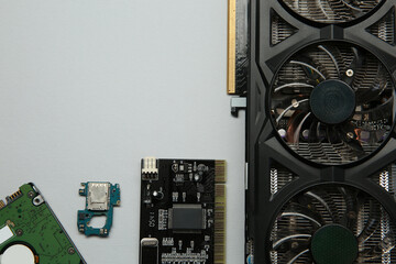 Poster - Graphics card and other computer hardware on light background, flat lay. Space for text