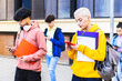 © Xavier Lorenzo - College students using mobile phone after classes while leaving university building campus.