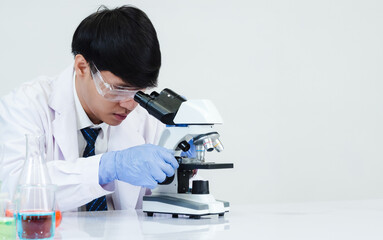 Wall Mural - Portrait asian man student scientist doctor in shirt gown one person wokk job plant looking hand holding control microscope on white table see the results of scientific experiments inside laboratory