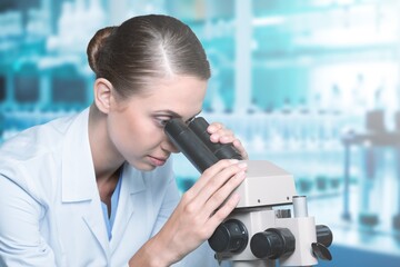 Wall Mural - Young researcher working examining samples with microscope