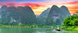 © huythoai - Ninh Binh, Vietnam - April 5th, 2024: Tourists float by boat on the river of the Tam Coc National Park Sightseeing tour to grottoes with sunset sky, Ninh Binh, Vietnam.