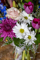 Wall Mural - Close up texture background of an indoor florist’s bouquet arrangement containing colorful flowers, with defocused background