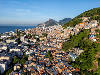 Wall Mural - Aerial view of the buildings on steep slopes surrounding Ipanema Beach at sunrise. Morning light on buildings by the coastline, Rio de Janeiro