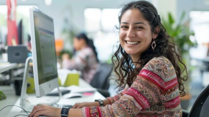 Poster - A woman is smiling and sitting in front of a computer
