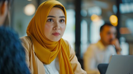 Poster - A modern office with a diverse workforce: Muslim businesswoman on Hijab, young Hispanic entrepreneur using laptops, talking with managers, brainstorming with young professionals. Young professionals