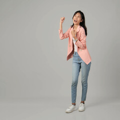 full lenght shoot of happy asian woman raising her fist. wearing formal casual outfit on isolated background.