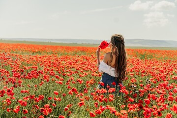 Canvas Print - Woman poppies field. Side view of a happy woman with long hair in a poppy field and enjoying the beauty of nature in a warm summer day.