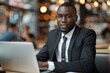 © AIGen - Business Executive Computer. African American Businessman Using Laptop in Cafe