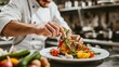 © Ruslan Gilmanshin - Professional Chef-cook Decorating Dish In Restaurant Kitchen Alone. Man In White Apron Makes Finishing Touch On DIsh, Adding Some Greens. Culinary, Restaurant