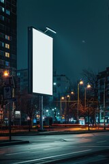 Poster - A blank billboard on a city street at night, perfect for advertising mockups or urban scenes