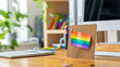 © peera - Modern office desk, rainbow flag pin, diversity and inclusion symbol