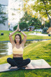© Strelciuc - Brunette adult woman sitting on black mat in lotus pose, keeping palms together, posing with closed eyes. Relaxing and meditation in open fresh air in forest