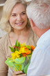 © Darren Baker - Happy Senior Man and Woman Couple With Flowers Smiling at Home