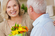 © Darren Baker - Happy Senior Man and Woman Couple With Flowers Smiling at Home