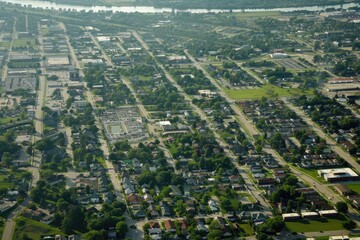 Poster - Aerial view of a city surrounded by green trees. Ideal for urban planning or environmental concepts