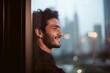 © alisaaa - Young man looking out of the window smiling